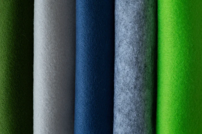 "Various colored sports fabrics stacked in a row, showcasing different textures for activewear clothing."
