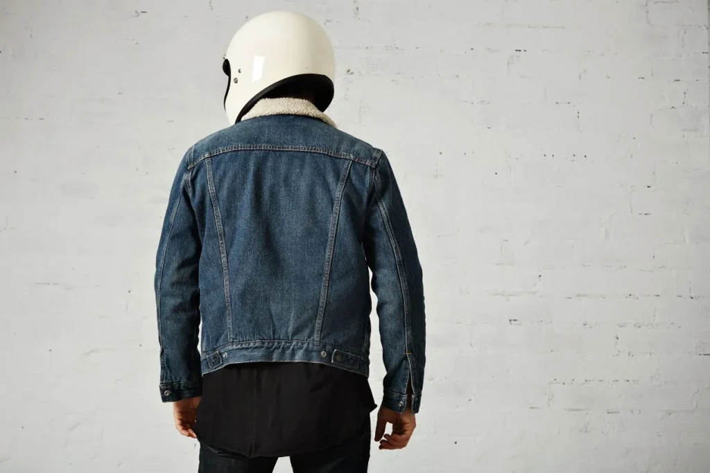 "Man wearing a denim jacket with a helmet, ideal for casual and motorcycle style."