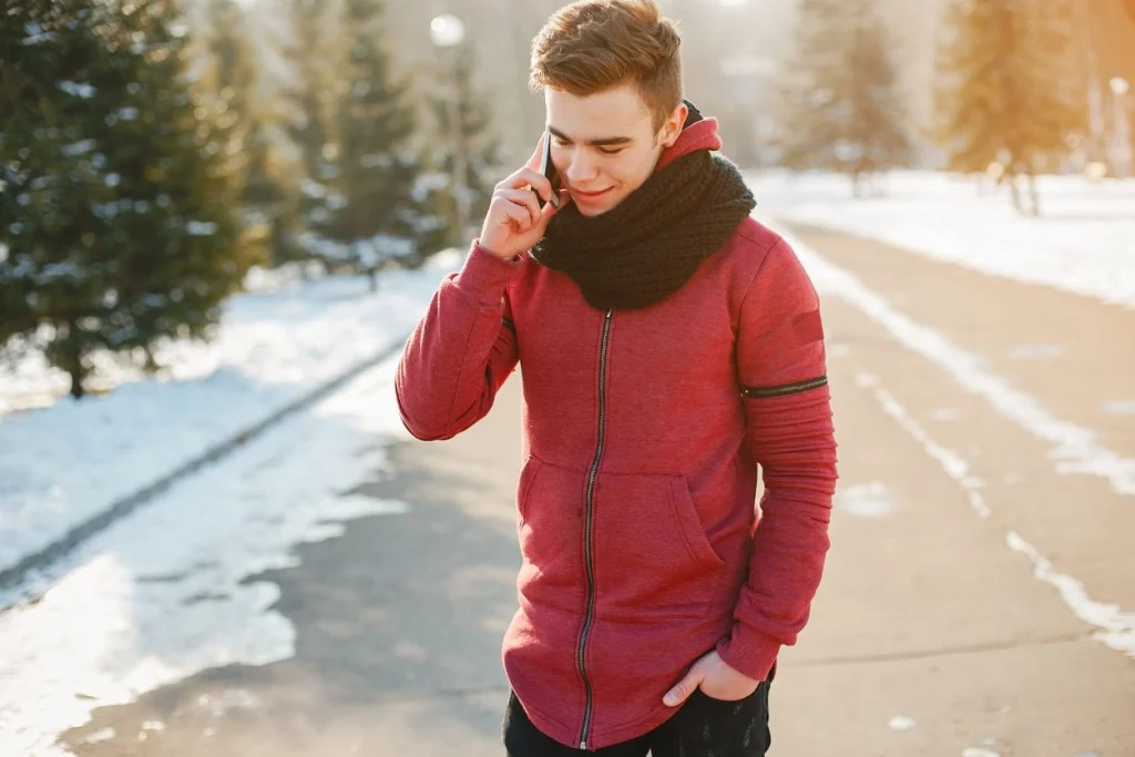 Young man wearing a red hoodie jacket with a black scarf, perfect for winter walks."