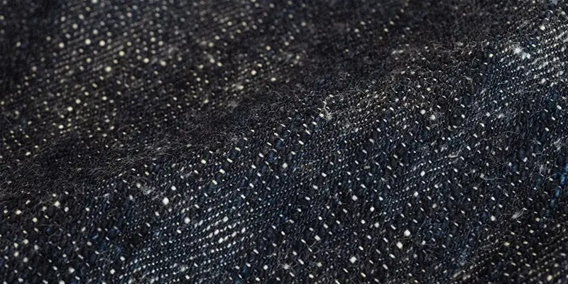 "Close-up of textured black denim, showcasing fabric for premium pant styles."