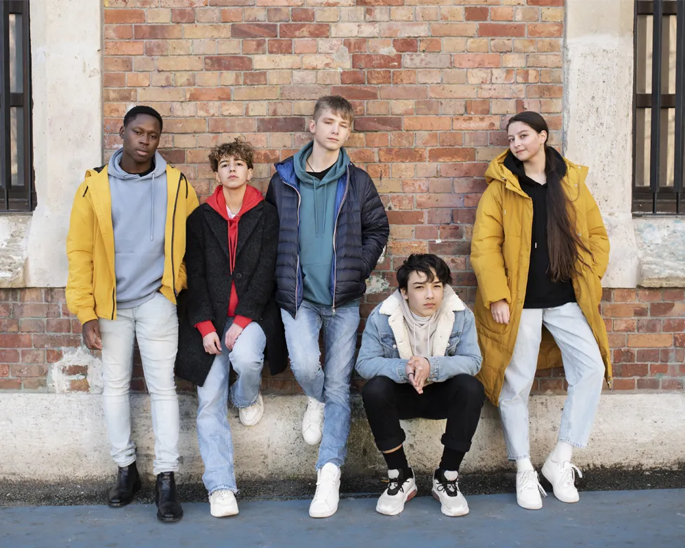 "Group of young people showcasing different types of jackets, including yellow raincoats, puffer jackets, and denim jackets."