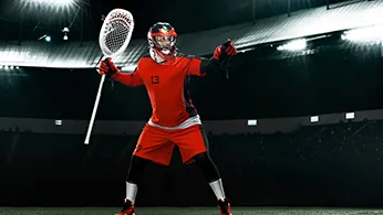a lacrosse player standing in the field equiped with full gear
