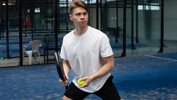 a tennis player havinhg a racket and ball in his hand