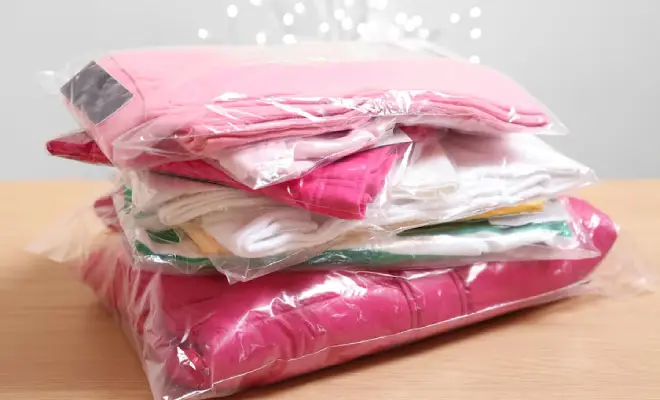A stack of vacuum-sealed bags containing clothes in various colors, ideal for storage and shipping.