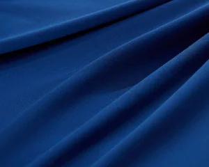 Close-up of smooth, deep blue lyocell fabric with soft folds and texture.