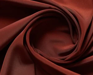 Close-up of luxurious, smooth red taffeta fabric with a glossy finish, showcasing its crisp texture and elegant appearance